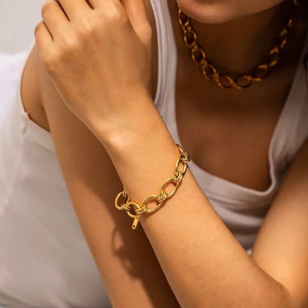 Johanna – Tunn guldarmband med detaljer av charm.
