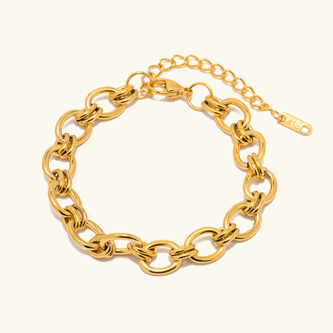 Johanna – Tunn guldarmband med detaljer av charm.