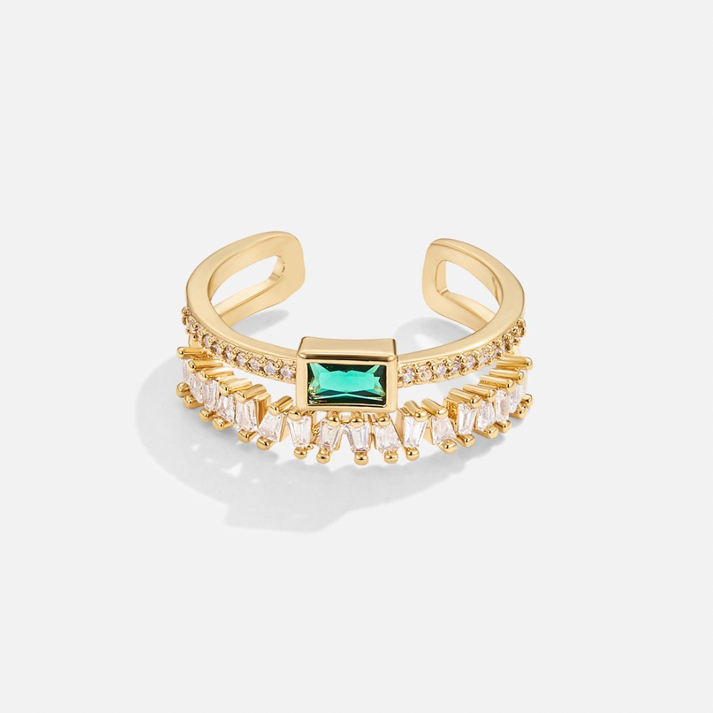 Sabina – Guld ring med gröna smaragd detaljer.
