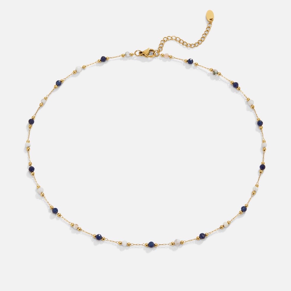 Theresa – Tunn halsband med diskreta detaljer i vitt och svart.