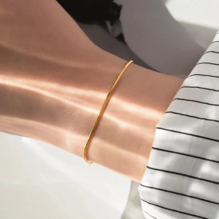 Carina – Guldarmband med glänsande platinastruktur.