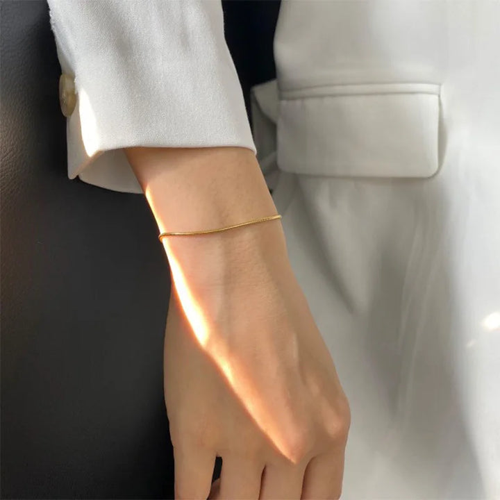 Carina – Guldarmband med glänsande platinastruktur.