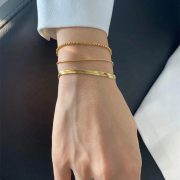 Carina – Guldarmband med glänsande platinastruktur.