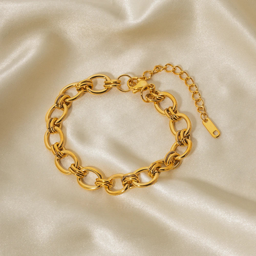 Johanna – Tunn guldarmband med detaljer av charm.