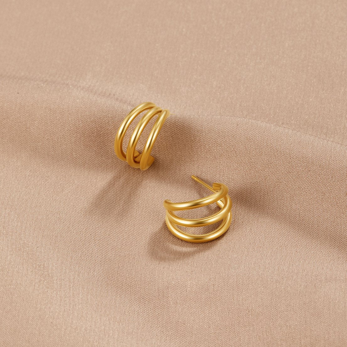 Eleni – Mini cirkulära örhängen i guld med textur.