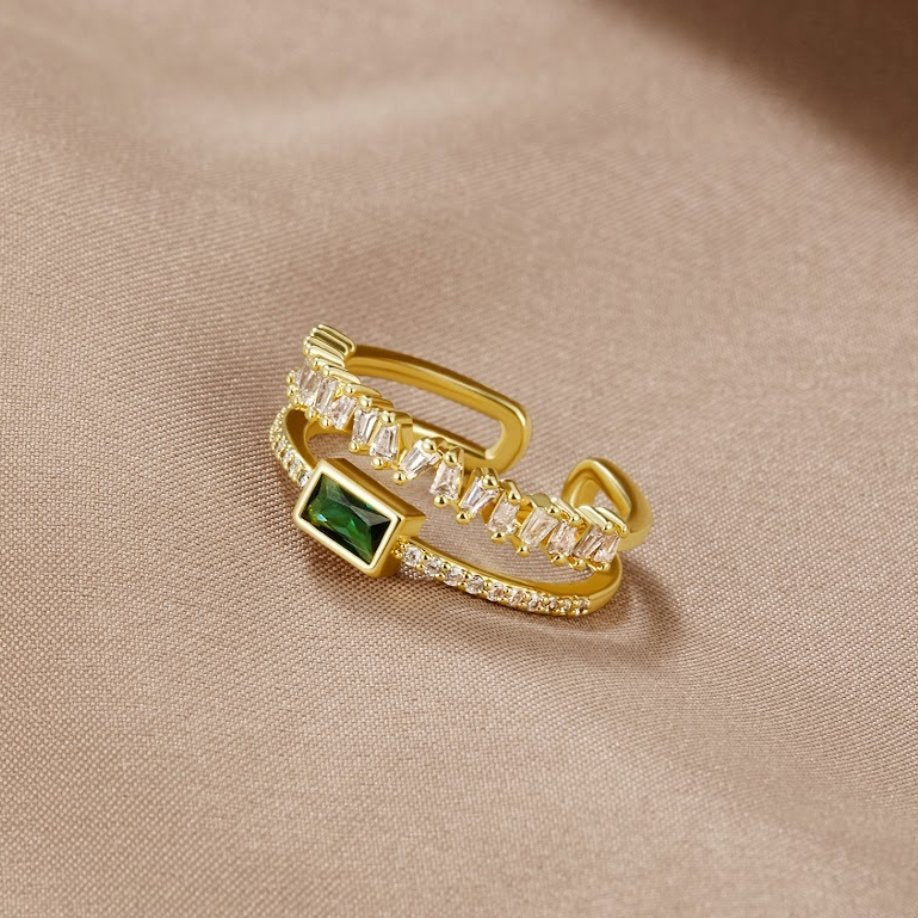 Sabina – Guld ring med gröna smaragd detaljer.