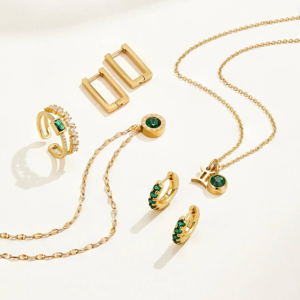 Sabina – Guld ring med gröna smaragd detaljer.
