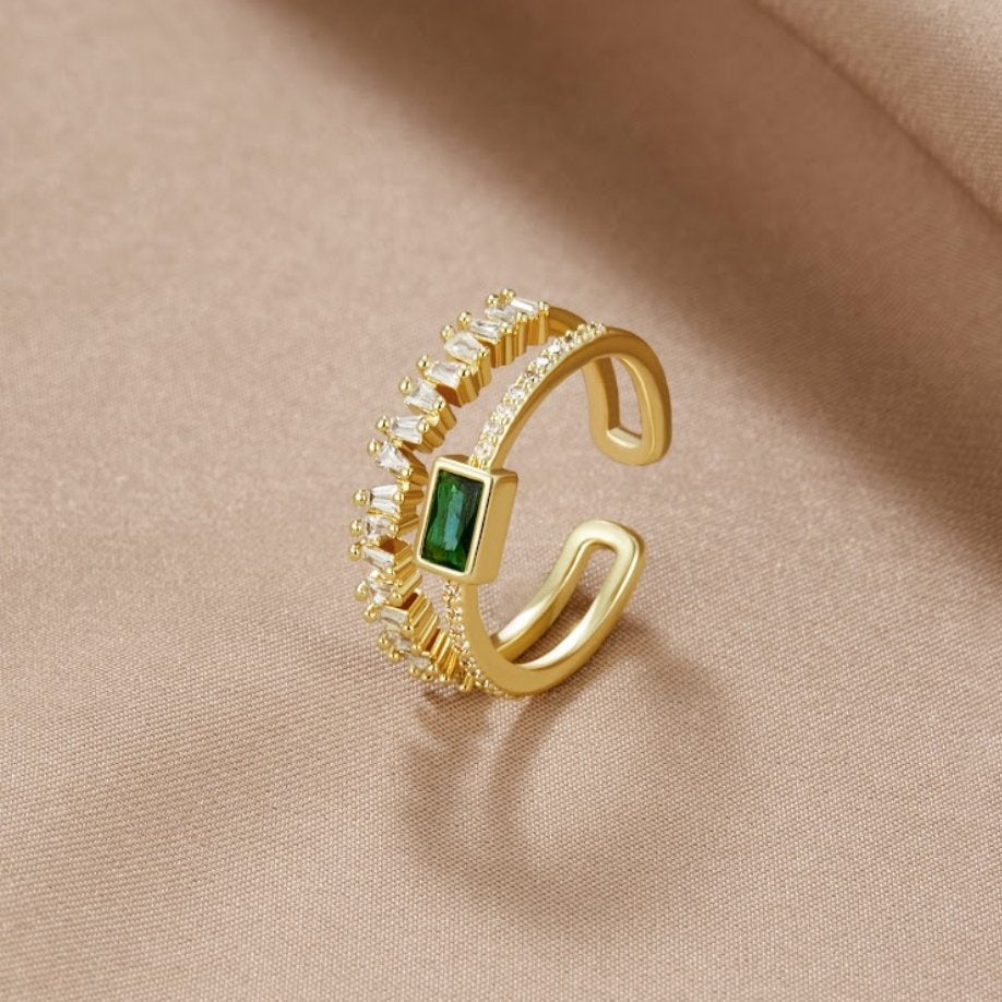 Sabina – Guld ring med gröna smaragd detaljer.
