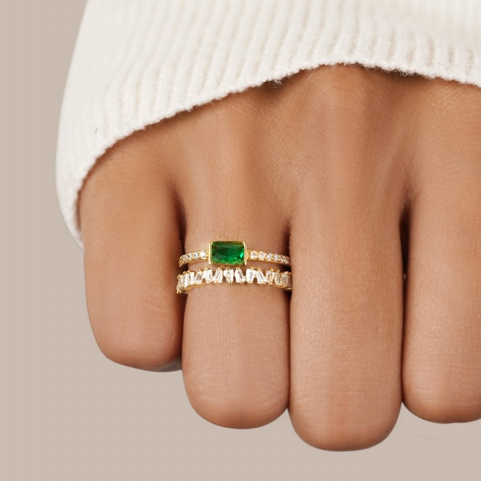 Sabina – Guld ring med gröna smaragd detaljer.