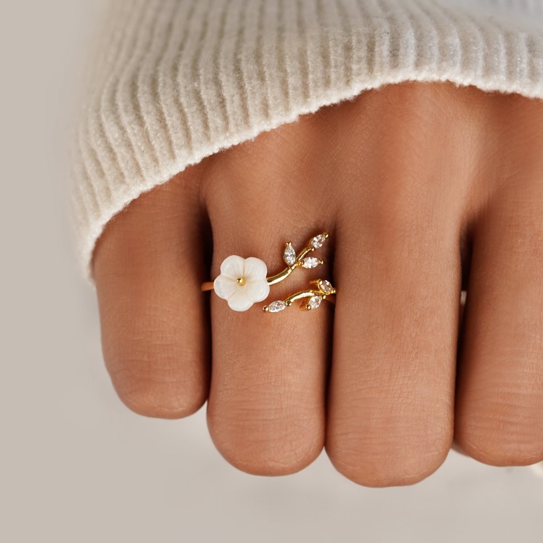 Miriam – Förlovningsring med vit blommig dekoration.